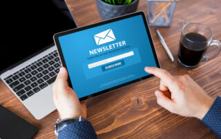 Person holding tablet with the word Newsletter