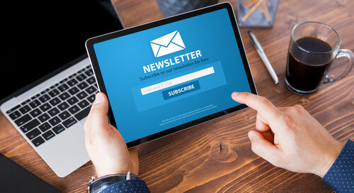 Person holding tablet with the word Newsletter