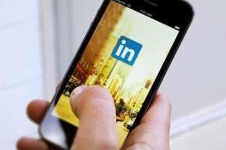 Person holding cell phone, LinkedIn app